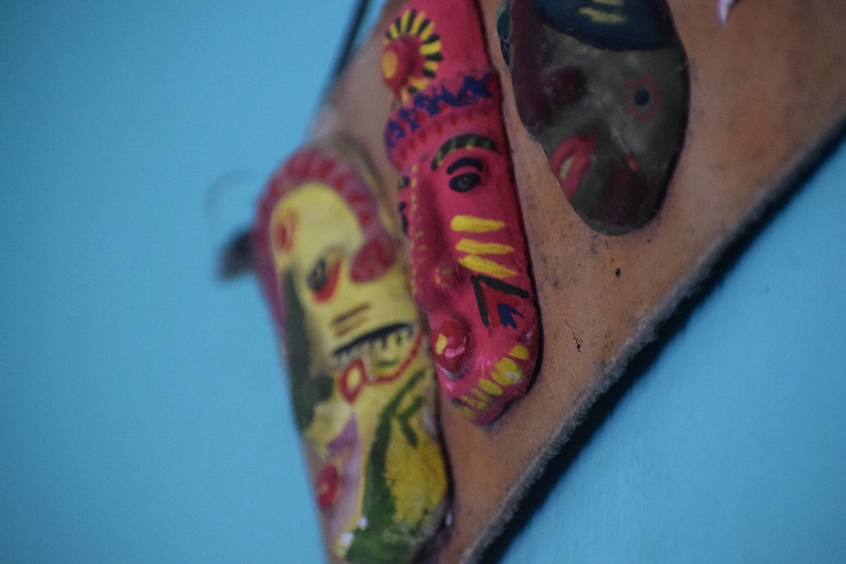 a group of colorful masks hanging on a wall