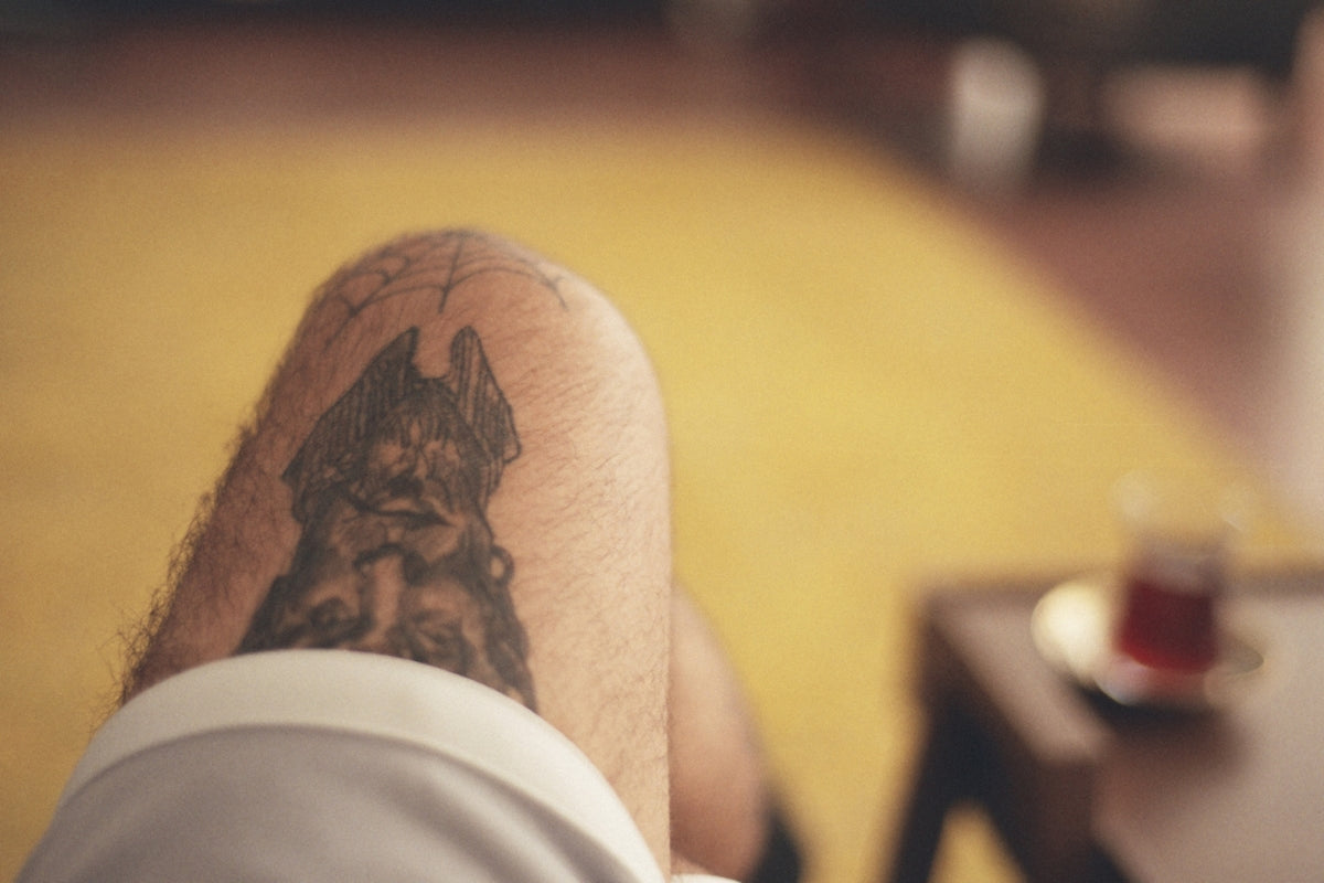 a man with a dog tattoo on his leg