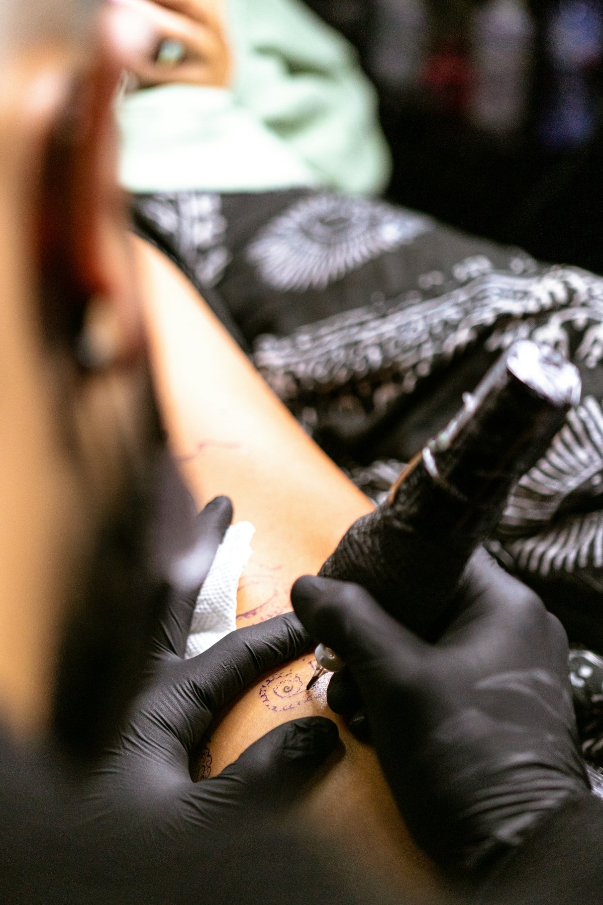 a man getting a tattoo on his arm