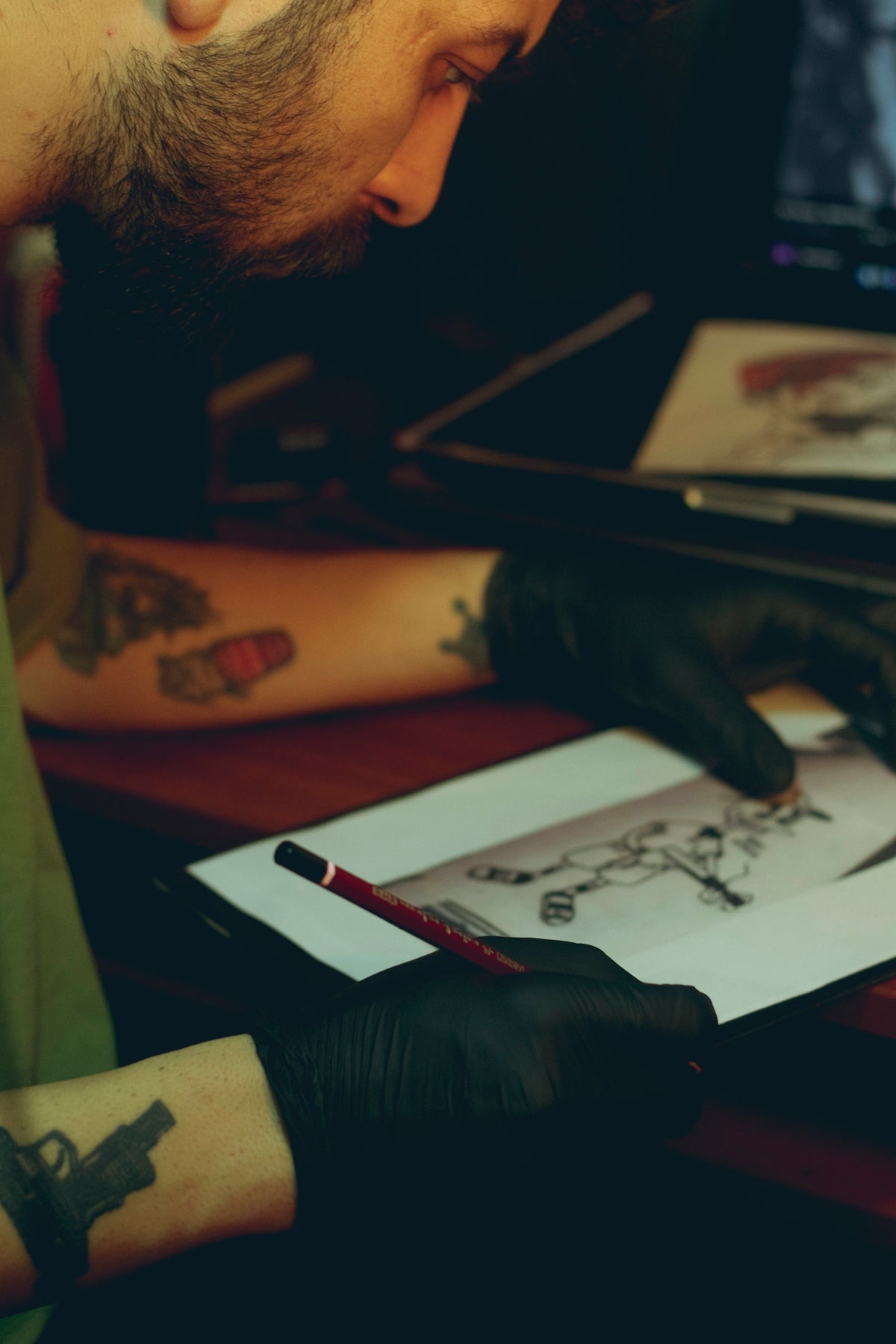 a man with a tattoo on his arm is looking at a drawing