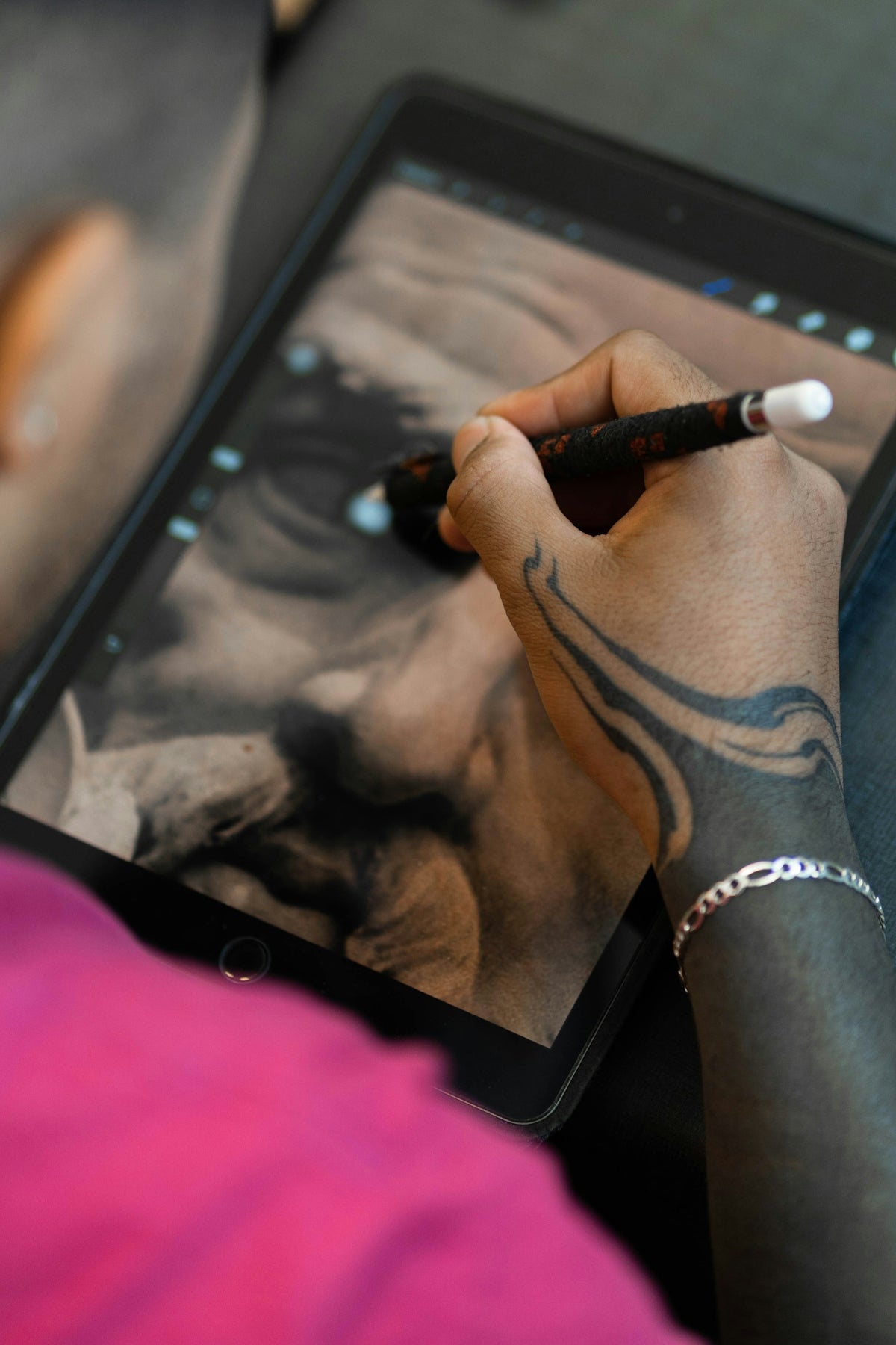 a person drawing on a tablet with a pencil