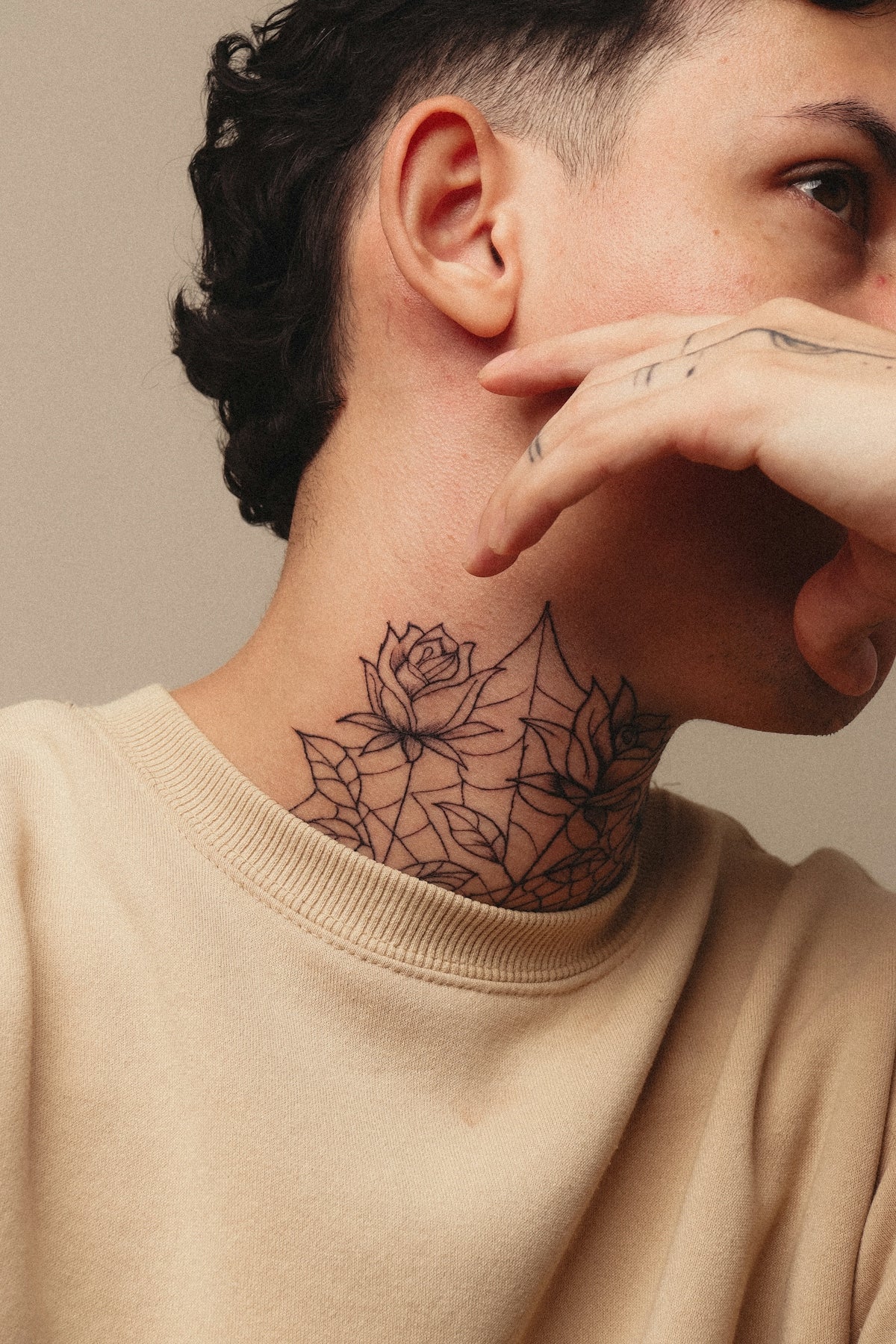 A person displays a neck tattoo and cool mullet.