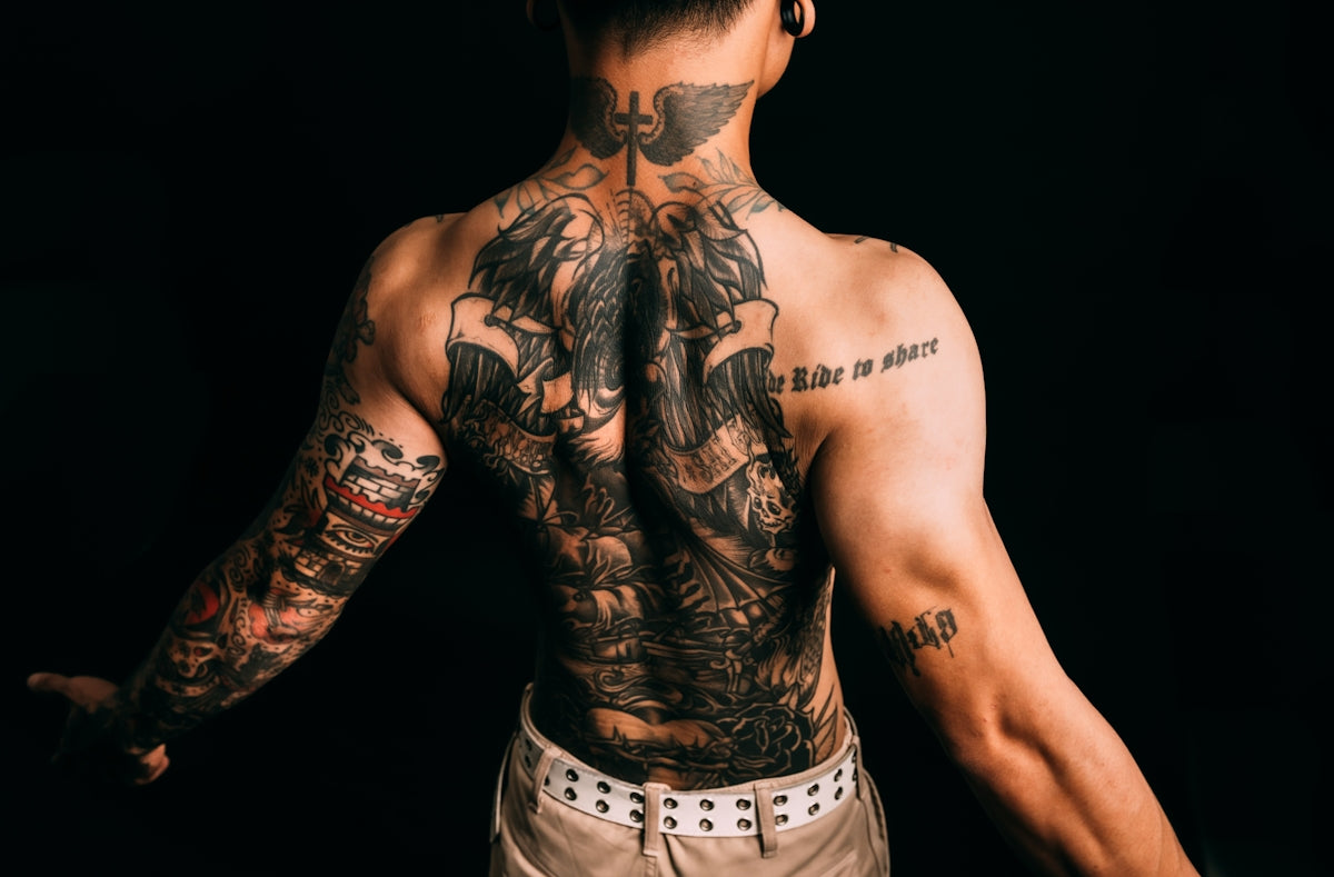 Man with elaborate full back and arm tattoos