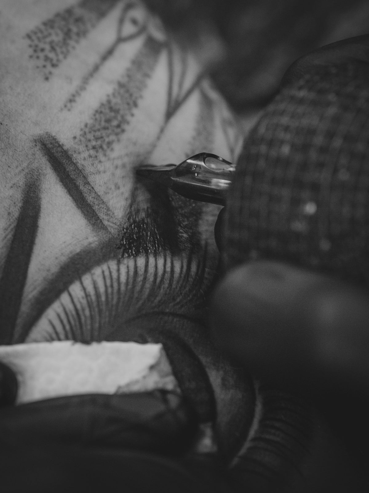 Tattoo artist working on client's arm