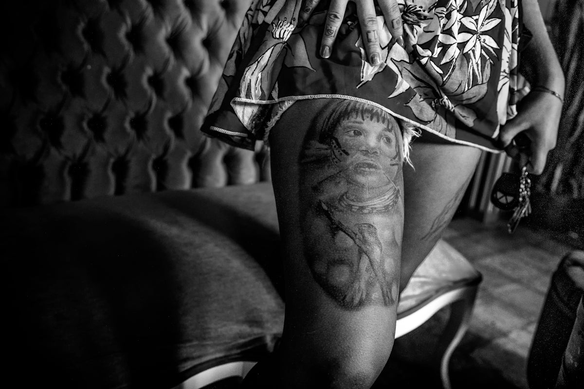 grayscale photo of person showing leg tattoo