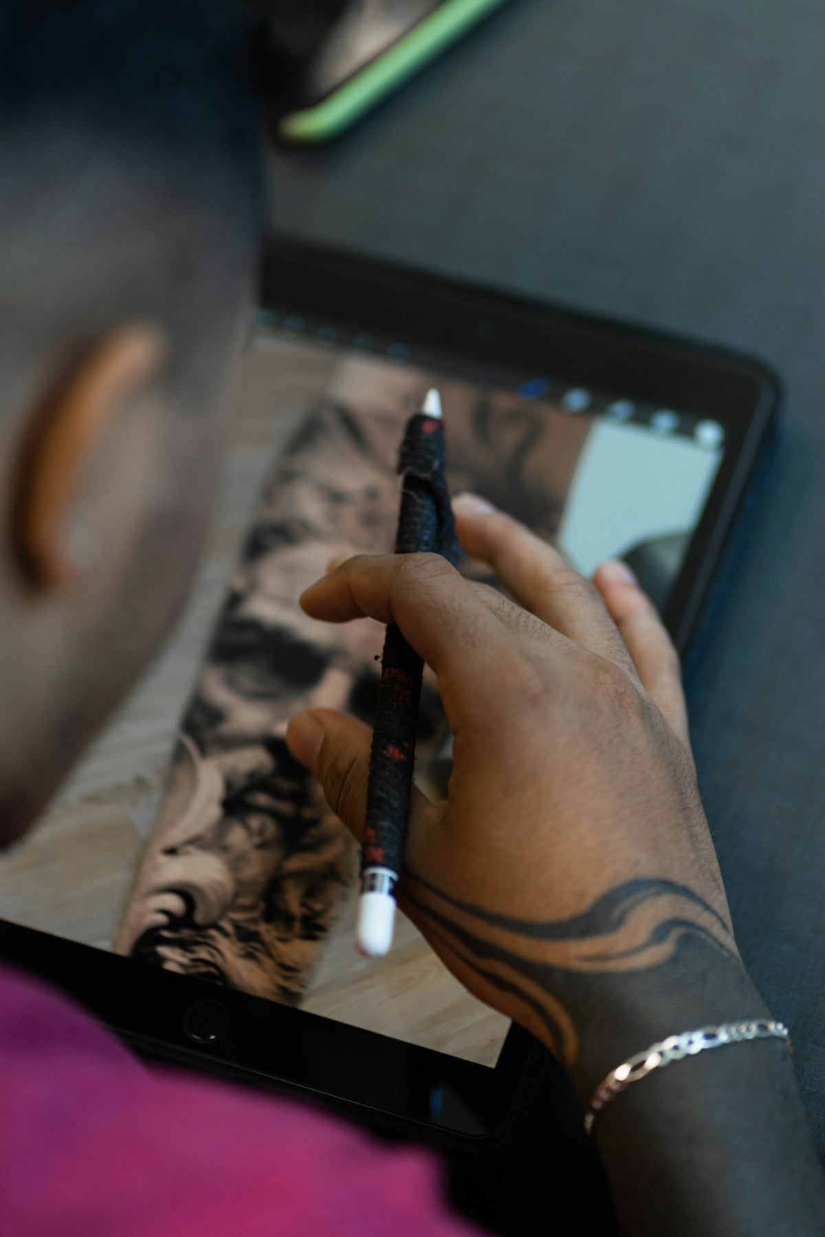 a man is drawing on a tablet with a pen