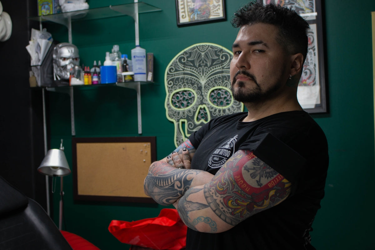 a man with tattoos standing in a room