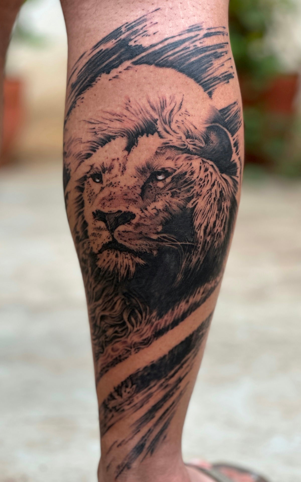A man with a lion tattoo on his leg