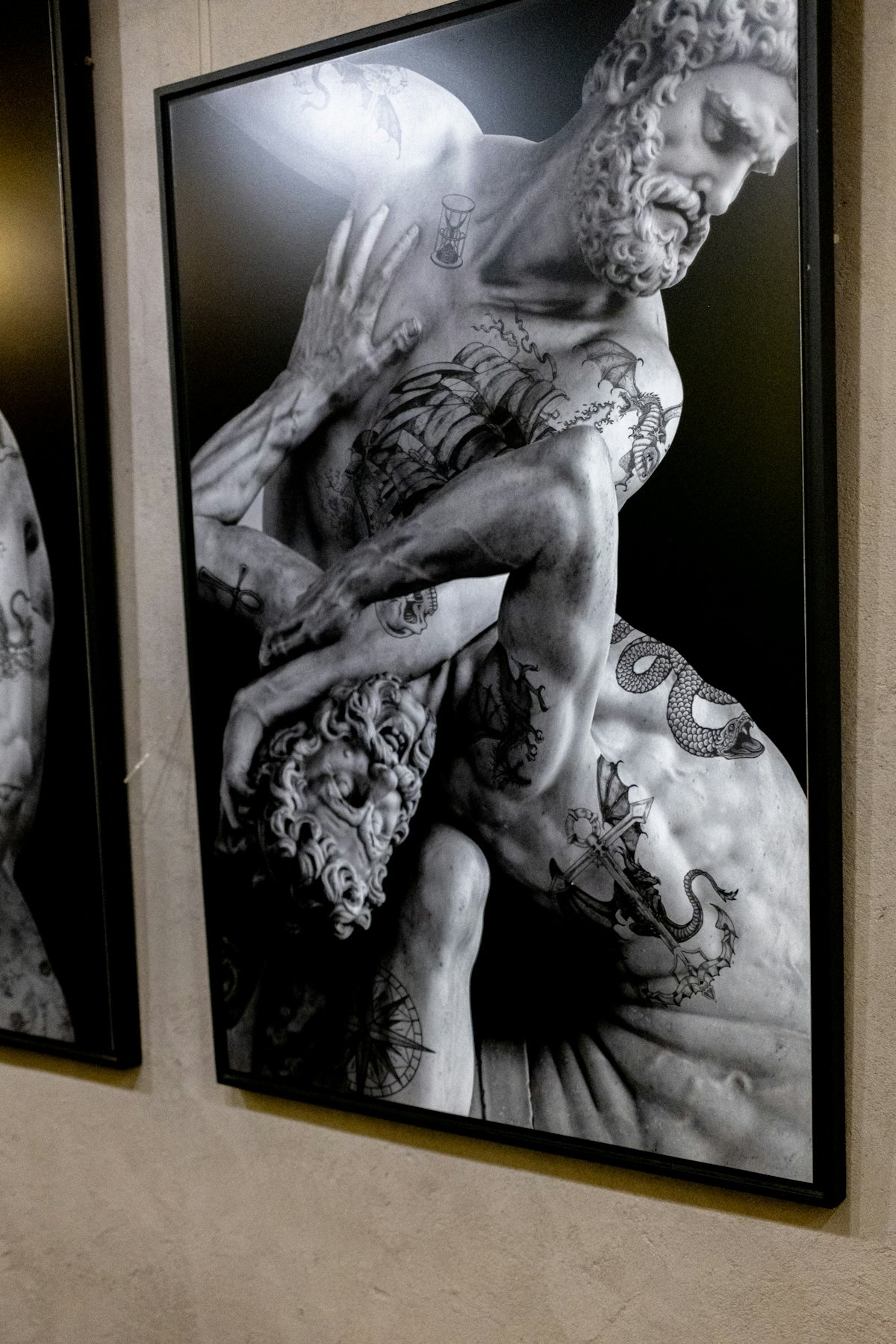 Tattooed marble statues in a dramatic wrestling pose.