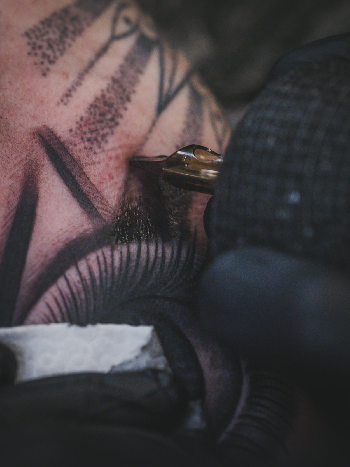 Tattoo artist inks design on client's face