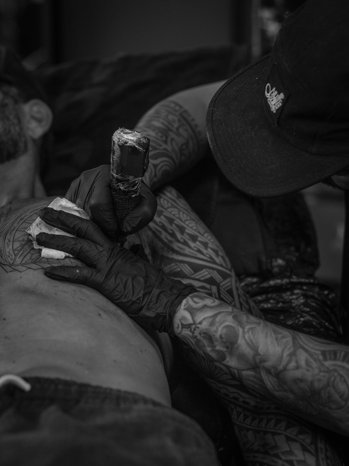 Tattoo artist applying ink to client's chest