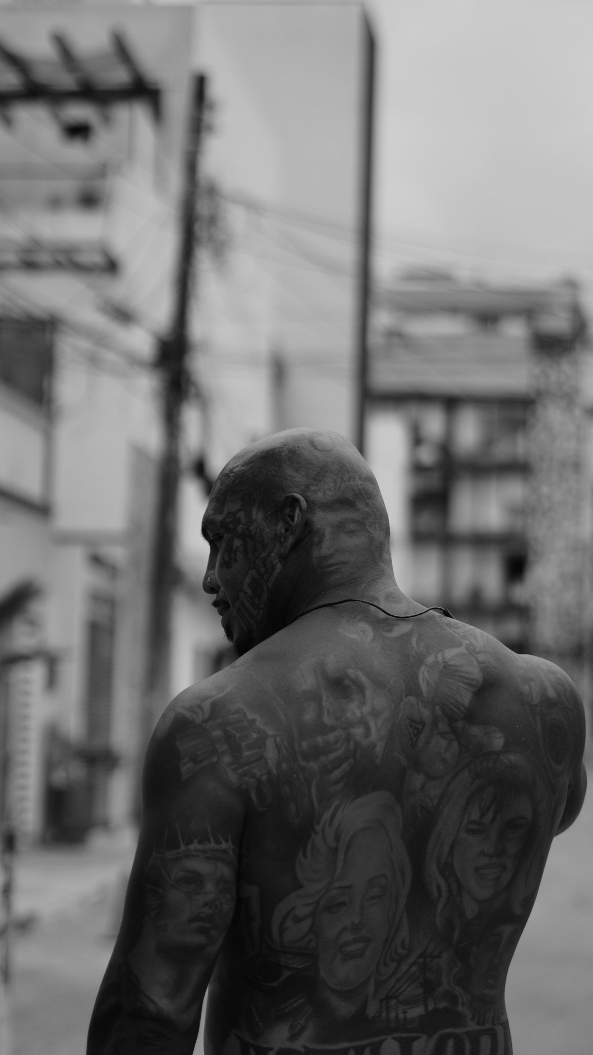 Man with extensive tattoos on his back and head.